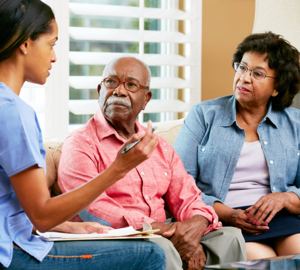 caregiver explaining to senior couple