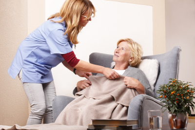 Woman taking care of her old patient in the living room